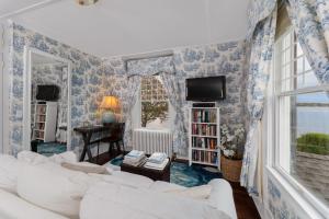 sala de estar con papel pintado de color azul y blanco en Harbor Knoll Bed and Breakfast en Greenport