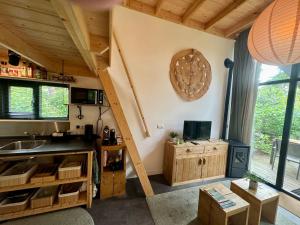 a living room with a staircase in a house at Tiny House op de Veluwe in Beekbergen