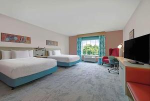 een hotelkamer met twee bedden en een flatscreen-tv bij Hilton Garden Inn in Manassas