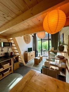 ベークベーゲンにあるTiny House met Hottub op de Veluweの木製の天井とテーブル付きのリビングルーム