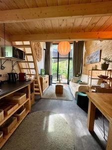 Tiny House met Hottub op de Veluwe في بيكبيرخين: غرفة معيشة مع أريكة وطاولة