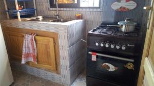 a small kitchen with a stove and a sink at Maison Rose+ in Douala