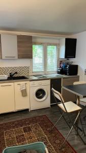 a kitchen with a washing machine and a table and chairs at Adorable studio 20m2 in Aubervilliers +7 photos