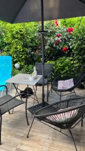 eine Terrasse mit einem Tisch, Stühlen und einem Sonnenschirm in der Unterkunft Adorable studio 20m2 in Aubervilliers