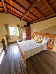 een slaapkamer met een bed en een houten vloer bij PENEDO ACONCHEGO LOFT: VISTA, CONFORTO E NATUREZA! in Penedo