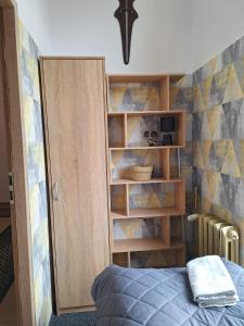 1 dormitorio con cama y estante para libros en Za zieloną bramą, en Zawiercie