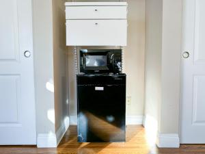 ロサンゼルスにあるMonthier Picfair Village CA1G6R23の電子レンジと黒い冷蔵庫のある部屋