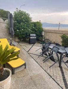 a patio with chairs and tables and an umbrella at PRIMERA LINEA PLAYA AMERICA in Nigrán