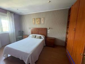 sypialnia z białym łóżkiem w pokoju w obiekcie O DESCANSO DE MANDUCA w mieście Mazaricos
