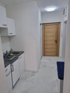 维也纳Royal Apartments的厨房铺有白色大理石地板，配有木门 更多3张照片