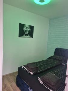 维也纳Royal Apartments的房间里的一张床，墙上挂着一个面具