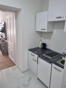 维也纳Royal Apartments的配有白色橱柜和台面的厨房