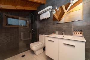 a bathroom with a white sink and a toilet at Tsokas Hotel in Finikounta
