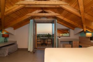 Habitación con techo de madera y habitación con mesa. en Tsokas Hotel, en Finikounta