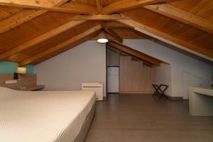 a large attic room with a bed and wooden ceilings at Tsokas Hotel in Finikounta