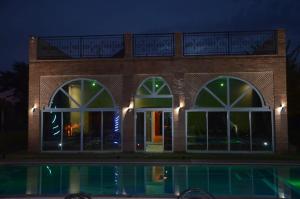a brick building with three windows and a pool at VillaAbrajeimmo in Marrakech