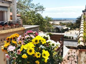 Un ramo de flores sentado en un balcón. en La Llar de la Kim, ideal familias, en Arenys de Mar