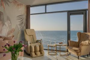 una sala de estar con sillas y vistas al océano. en Apartament Nadmorski Luksus - Boulevard, en Ustronie Morskie