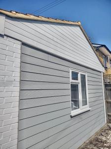 a white house with a window on the side of it at Studio flat in Goring by Sea
