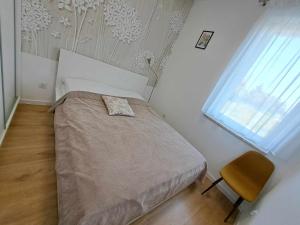 una camera con un letto e una sedia e una finestra di Apartament Więcbork a Więcbork