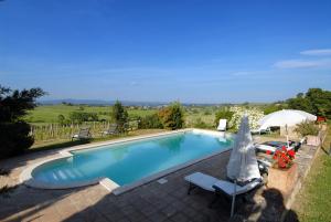 a large swimming pool with an umbrella and an umbrella at Tenuta Santagnese in Montepulciano