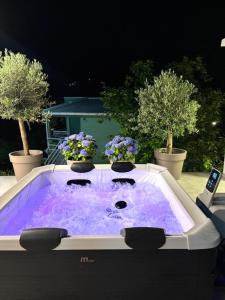 a hot tub sitting on a patio with purple water at Apartments MIONA in Virpazar
