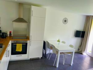 a kitchen with a table and a white table and chairs at Nature Studio Deck - 3 countries - Free Parking in La Calamine