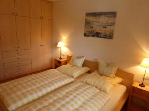 a bedroom with two beds and two lamps in it at Ferienwohnungen Florian Pletzenauer in Gstadt am Chiemsee