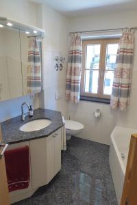 a bathroom with a sink and a toilet and a window at Ferienwohnungen Florian Pletzenauer in Gstadt am Chiemsee