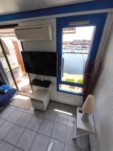 a room with a computer monitor and a window at Appartement Port Barcarès Vue Marina in Le Barcarès