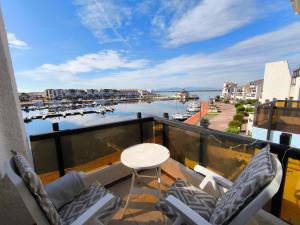 a balcony with chairs and a table and a view of a harbor at Appartement Port Barcarès Vue Marina in Le Barcarès