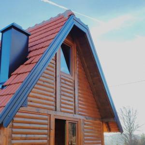 a cabin with a red roof and a window at vikendica tarska car in Mitrovac