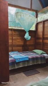 a room with a bed with an umbrella on it at JARDIN DE LAS MUSAS in Puerto Maldonado