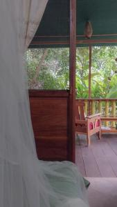 a bedroom with a bed and a balcony with a window at JARDIN DE LAS MUSAS in Puerto Maldonado