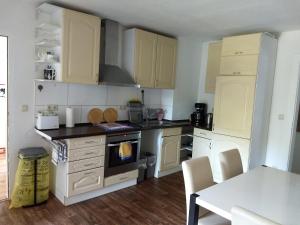 a kitchen with white cabinets and a white table with a tableablish at WiW - Wohnen in Wathlingen in Wathlingen