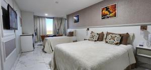 巴西利亚Antonio's Hotel e Spa - Airport的一间配有床和电视的酒店房间