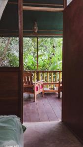 Zimmer mit einem Balkon mit einer Bank auf einer Veranda in der Unterkunft JARDIN DE LAS MUSAS in Puerto Maldonado