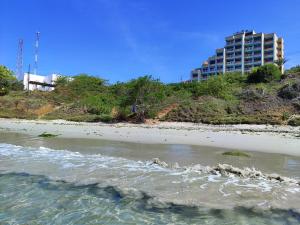 vistas a una playa con un edificio en el fondo en Playa dorada en Pampatar