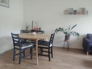 mesa de comedor con sillas y sofá azul en Gastvrij verblijf in gezellig dorp dichtbij natuur en Enter