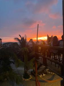 un grupo de personas viendo la puesta de sol en un complejo en Un Dia Boutique Resort en Playas