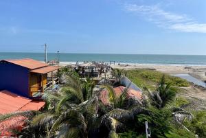 普拉亞斯的住宿－Un Dia Boutique Resort，棕榈树和大海海滩上的度假屋