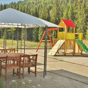 a playground with a table and benches and a slide at Тайната квартира - The Secret apartment in Pamporovo