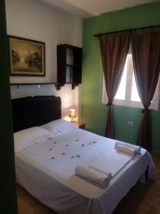 a bedroom with a bed with white sheets and a window at Katia's Apartments in Sarti