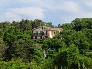 a house on top of a hill with trees at Casa Il Volo in San Zeno di Montagna