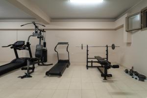 a gym with several tread machines in a room at Tsokas Hotel in Finikounta