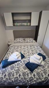 a bed with two towels on top of it at Mobile Home Relax in Pirovac