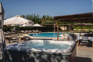 a swimming pool with a hot tub in a patio at Tsokas Hotel in Finikounta
