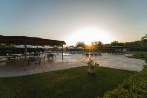 a patio with tables and umbrellas and a pool at Tsokas Hotel in Finikounta