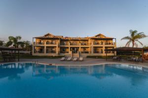 a large building with a large pool in front of it at Tsokas Hotel in Finikounta