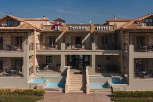 a large building with a hotel with stairs and tables at Tsokas Hotel in Finikounta